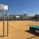 Basketballständer auf Sportplatz, rechts Hochsprungmatte